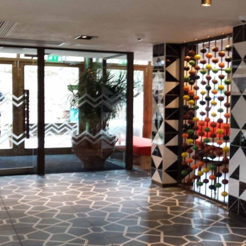 Restaurant entrance with charcoal hexagon floor tiles and black and white geometric wall tiles